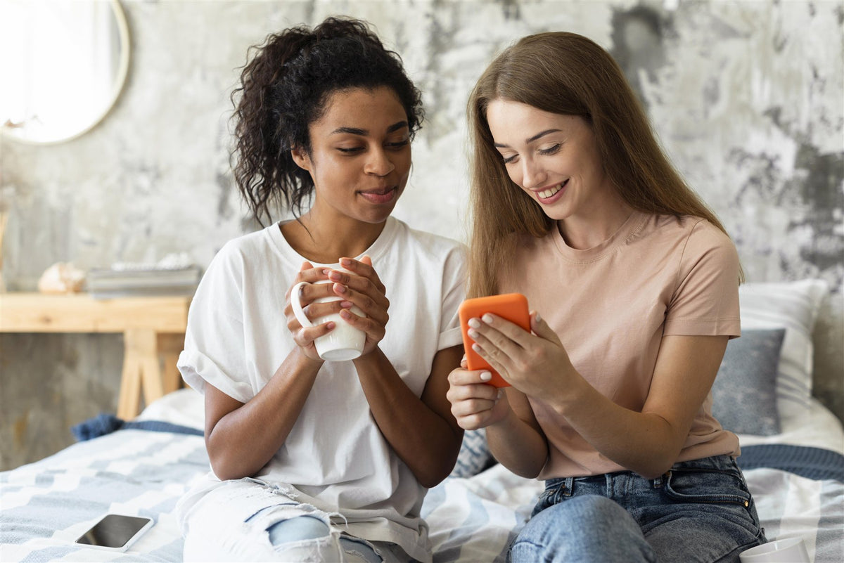 Zwei Freundinnen schauen gemeinsam auf ein Smartphone